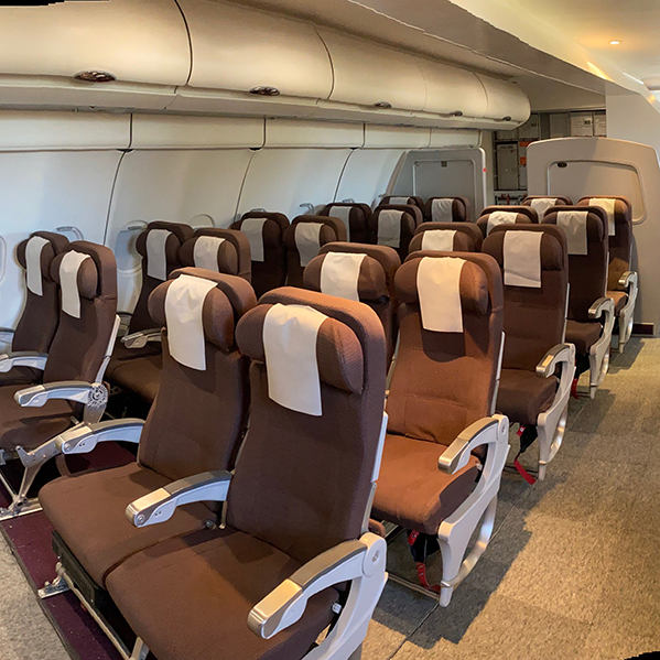 Seating area of Airplane Cabin mock-up, including life jackets, seatbelts, and overhead bins at the WFC Training Facilities.